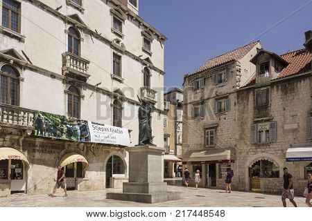 SPLIT. CROATIA - AUGUST 11 2017: Fruits square and its ancient building in Split with the monument to poeat Makus Marulic