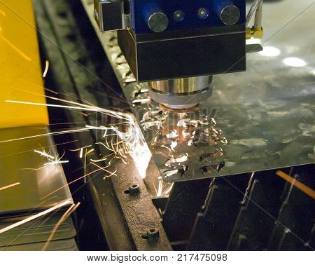 Fiber laser machines for metal cutting close-up. A laser beam cuts the sheet metal in the manufacture. Industrial technologies, production processes