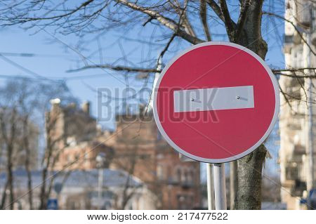 Round red road sign on metal pole. No Entry road-sign mounted on urban roadside