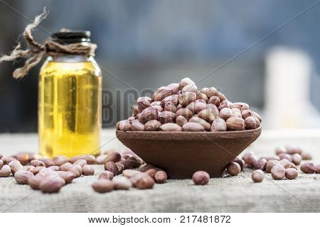 [arachis Hypogaea] Raw Groundnut In A Clay Bowl With Groundnut Oil On A Gunny Background.;