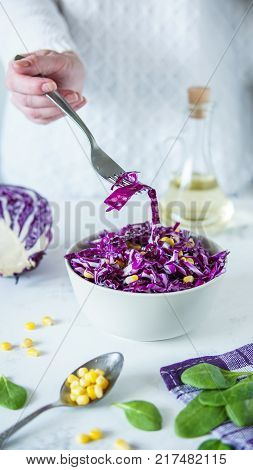 Salad Of Red Cabbage And Corn. Woman's Hand Holds Fork With Salad