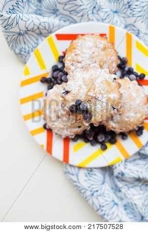Blueberry muffins on plate and bright floral napkin, close-up