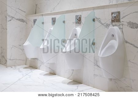 Row of urinals men public toilet Closeup white urinals in men's bathroom design of white ceramic urinals for men in toilet room