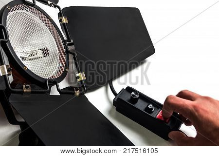 The male hand holds a finger on the light device switch.