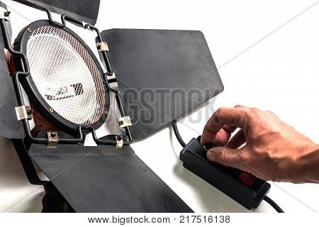 The man adjusts the brightness on the device for photo-video lighting.