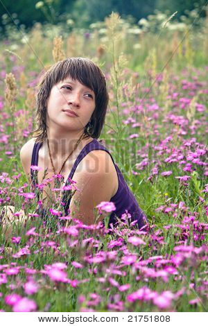 Krásná dívka sní a pole plné květin