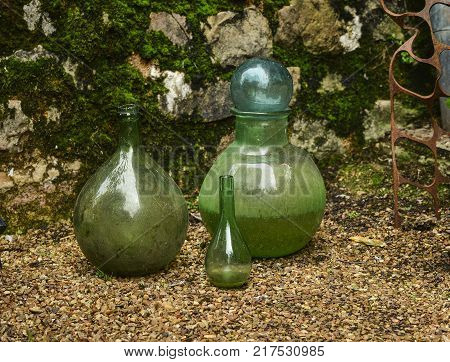 Green glass flasks on the background of a stone wall with a mold