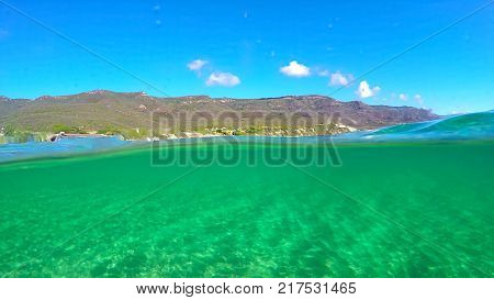 Split underwater view of La Speranza beach turquoise water Sardinia