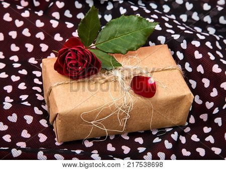 gift Packed in craftool paper with a dark red rose on fabric heart