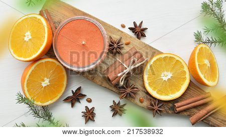 fresh oranges with anisestars, cinnamon sticks, juniper branches and aroma candle, Christmas time composition, top view