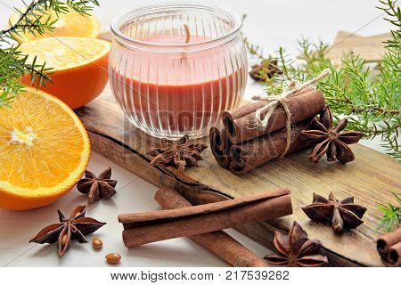fresh oranges with anisestars, cinnamon sticks, juniper branches and aroma candle, Christmas and New Year time composition