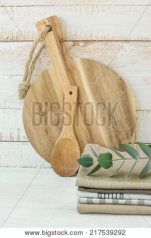 Round Artisan Wood Cutting Board Spoon Stack of Linen Cotton Kitchen Towels on White Table Scandinavian Provence Style Kinfolk Store Website Banner Template Copy Space