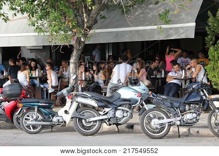 THESSALONIKI, GREECE - SEPTEMBER 26, 2012: Unidentified youth rest in cafes which stretch endlessly along the city embankment.