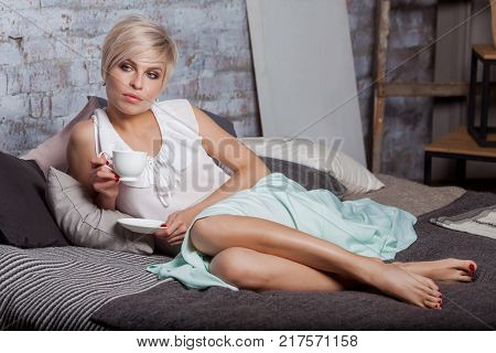 Beautiful Woman Sitting On Leather Sofa