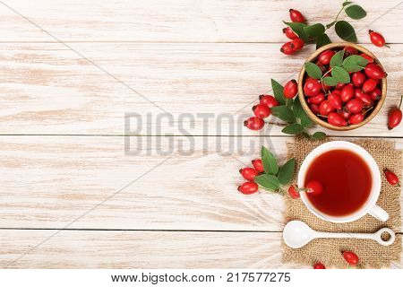 tea with rose hips and honey on a white wooden background with copy space for your text. Top view.