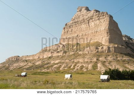 Wagons are situated at the base of Scott's Bluff in Nebraska