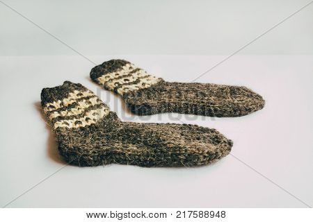 Stack Of Handmade Warm Knitted Socks Scarfs Mittens From Rough Wool Yarn Brown Beige Grey On Wood Ta