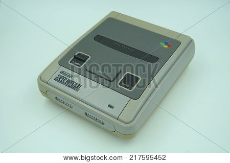 Almere, Netherlands-  December 9, 2017: Classic Super Nintendo (SNES) video game console deck against a white background.  The 16-bit SNES is was one of the most popular game consoles during the '90s.