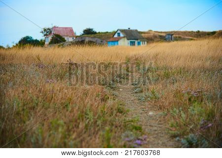 Path leading to a small old russian village on the background