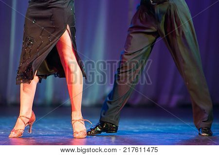 passion, showing, clothes concept. man and woman are performing a latin american dance on the stage, they are perfectly dress in stilish black and dark blue coloures