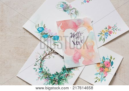 holidays, painting, arts and crafts concept. on the desk there are different pictures that are made with watercolors of various coloures for decoration of greeting cards