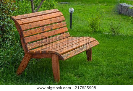 wooden bench on a lawn with green grass.