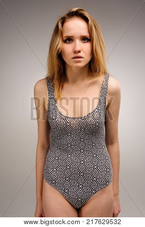 Young beautiful fashionable deplorable model over grey background. Side view