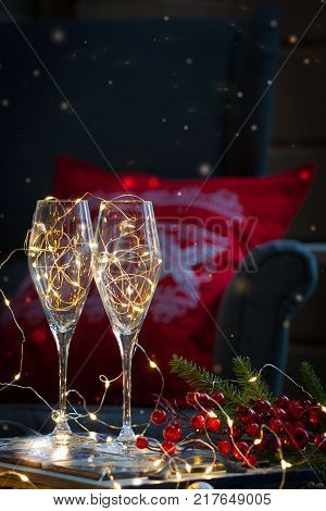 Postcard with Christmas shampagne glasses on the handmade tray over the red and white embroidered pillow with deer. Toned.
