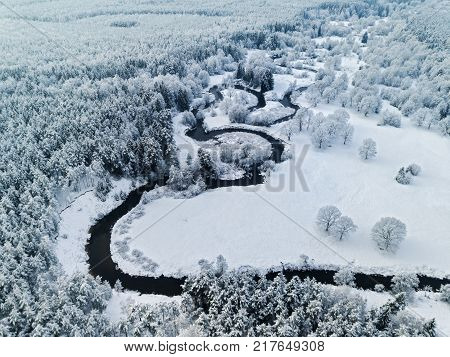 Amazing wild river in blue frozen forest. Really snowly winter on the north. Aerial panoramic view.