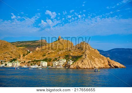 Cliff with tower and historical fortress on the entrance to a bay