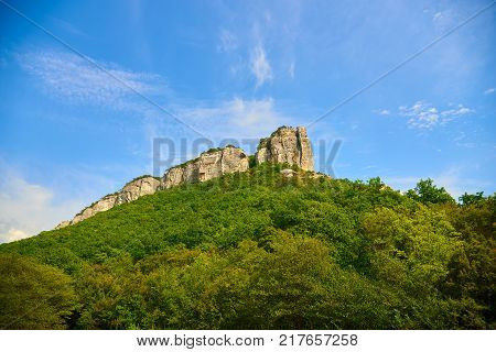 Green hill with rocks on the top