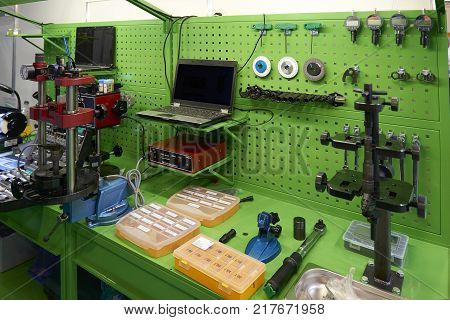 View on green working place with equipment and tools for car trucks components parts details diagnostic calibration maintenance repair works. Car diagnostic station. Car maintenance MOT equipment
