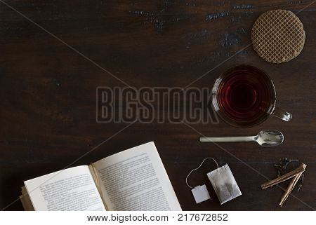 beautiful cozily flat lay of cup of tea book cookie and spices on rustic wooden ground