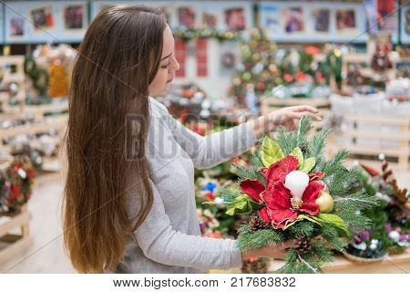 customergirl taking Christmas decorations. Various choice of New Year's wreath with decorations