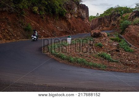 A road with curves going uphill and vehicle