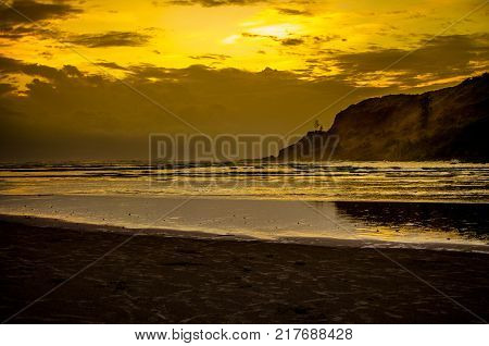 Golden sunset near a beach beautiful reflection of the hill