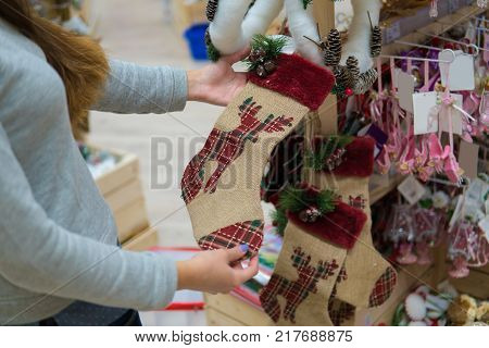customer girl choosing gifts for Christmas and New Year. She is holding stocking decoration with Reindeer