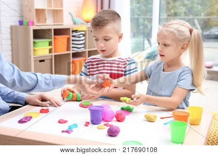 Little children engaged in playdough modeling at daycare
