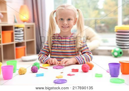 Little girl engaged in playdough modeling at daycare