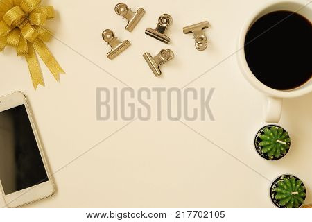 top view of ribbin bow, coffee, phone, paperclip and cactus background