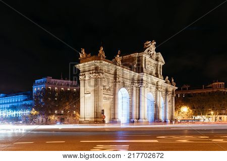Madrid, Spain - December 8, 2017: Puerta de Alcala in Madrid at night on Christmas time with light trails of traffic