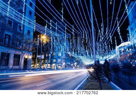 Madrid, Spain - December 8, 2017: Alcala Street in Madrid at night on Christmas time. Long exposure shot with light trails of traffic and blurred people
