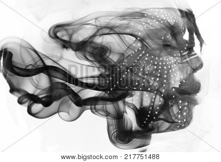 Double exposure of dark-skinned man with traditional style face paint dissolving behind smoke texture resembling ink in water
