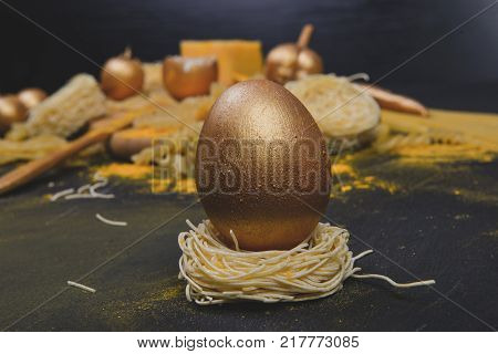 Italian food .Golden ingredients for cooking pasta with board on dark background.Top view