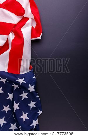 American flag US symbol lies unevenly vertically on the left close-up on a gray background