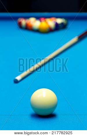Billiard pool game eight ball with eightball balls set up with cue on billiard table with blue cloth