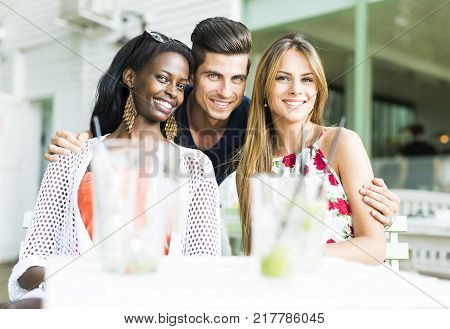 Happy young friends smiling outdoors being close to each other on a summer day