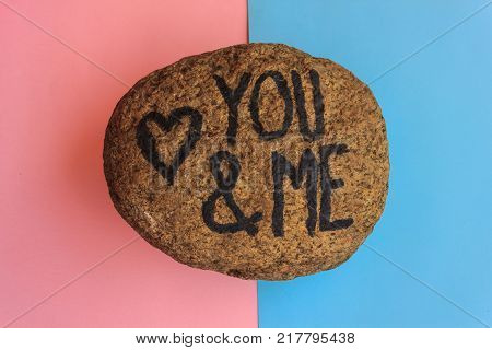 the english  writing you and me with a heart drawn on a stone, the writing you and me with a heart drawn on a stone indicates the love promise of two lovers