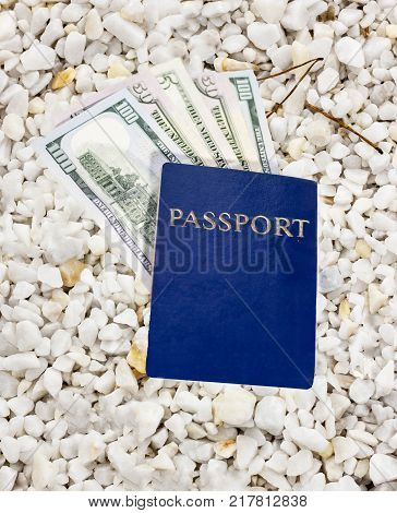 Dollars in blue passport on pebble pebble shingle close-up