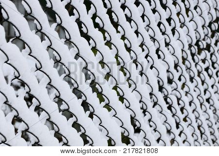 steel black mesh fence in white snow